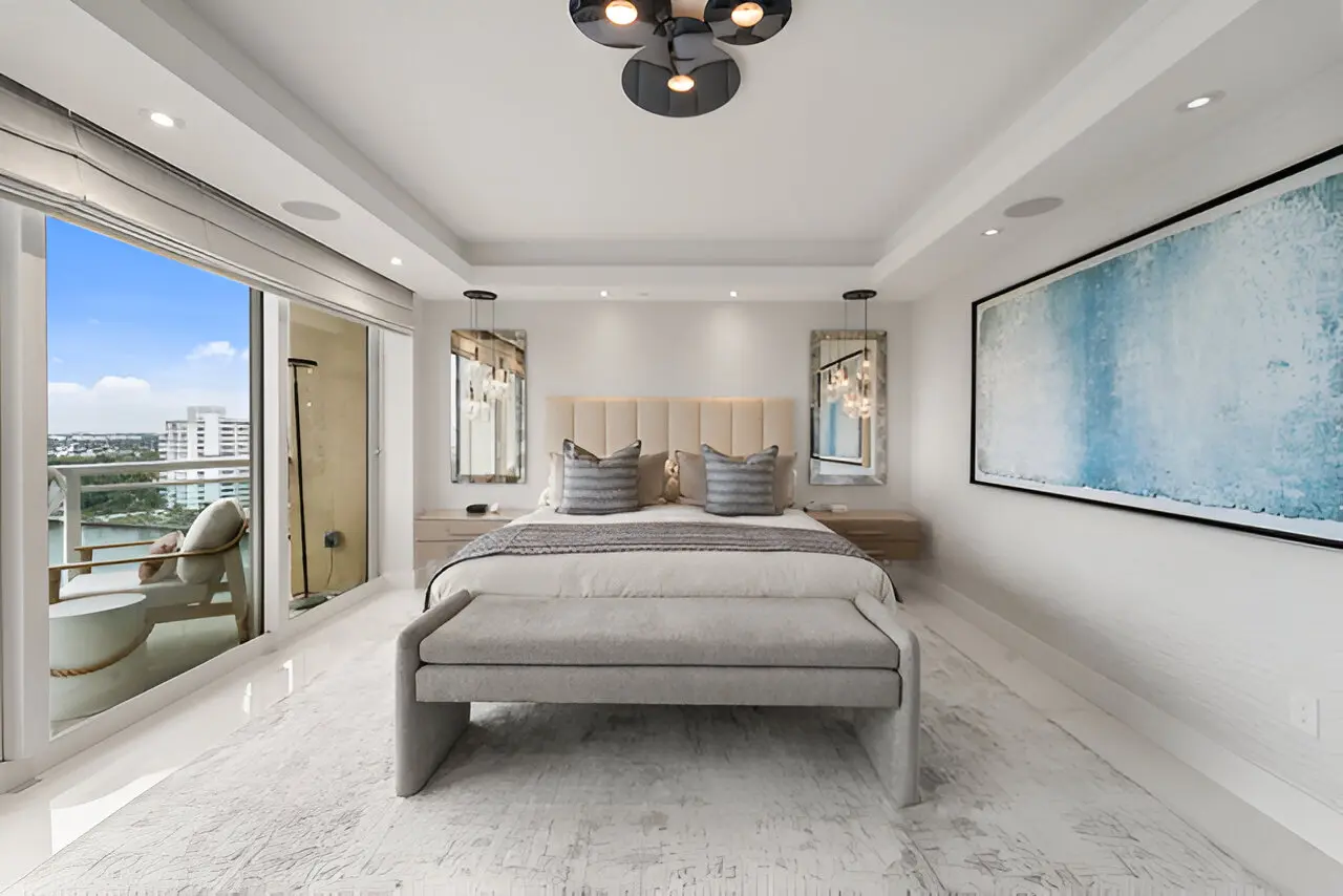 A bedroom with a large bed and a balcony.