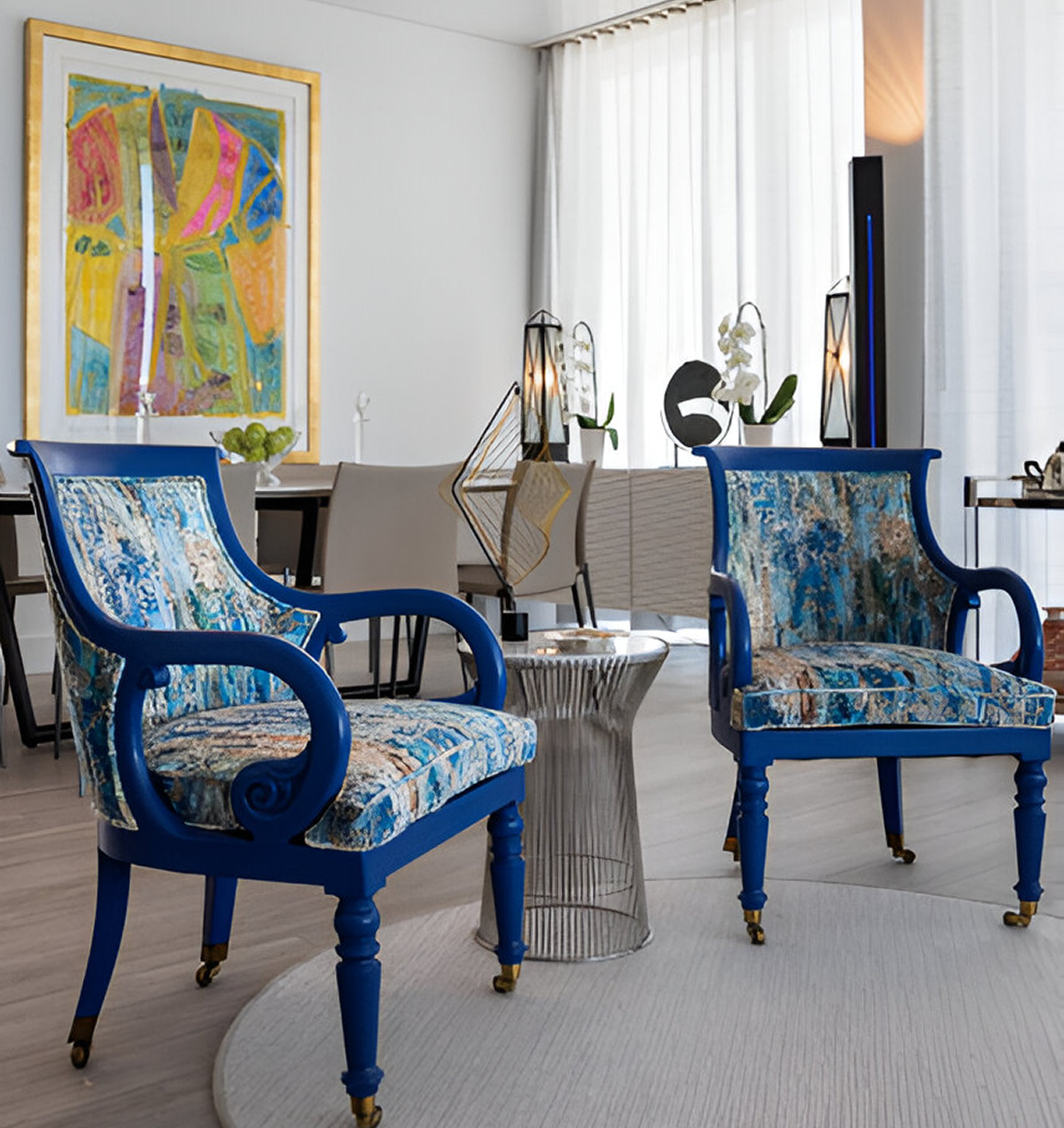 Two blue chairs in a room with a table and chair.