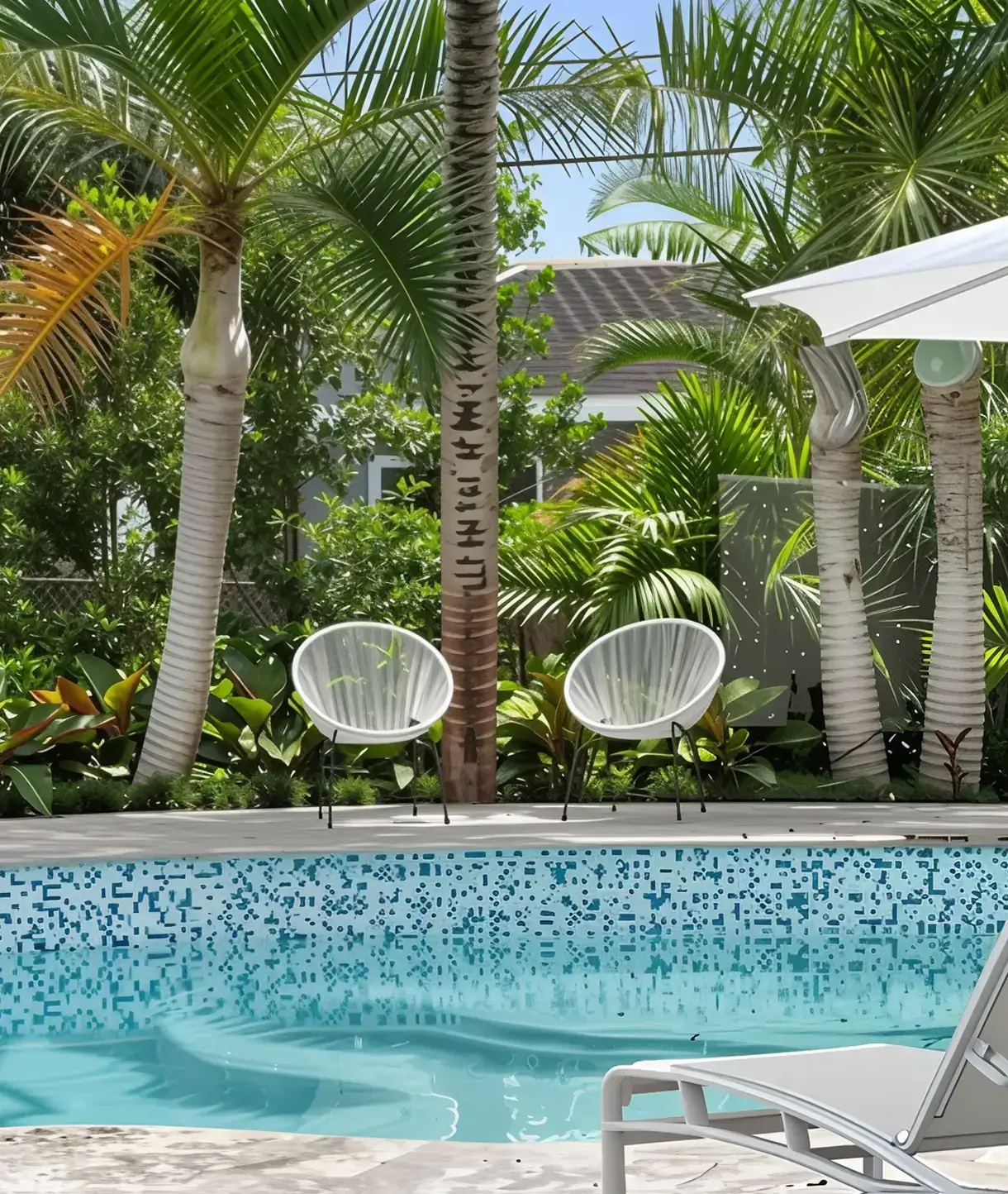 Tropical poolside with palm trees and chairs.